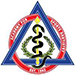 The image displays a logo consisting of a shield with a crest at its center, featuring an emblem with a snake wrapped around a staff and a pair of wings, with two crossed swords above it. Surrounding the shield are various elements including the letters  AMA  in large font, a laurel wreath, and other decorative symbols. The background is white.